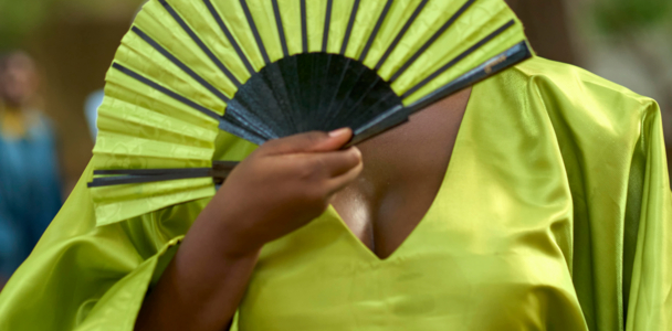Frau in grünem Boubou mit Fächer