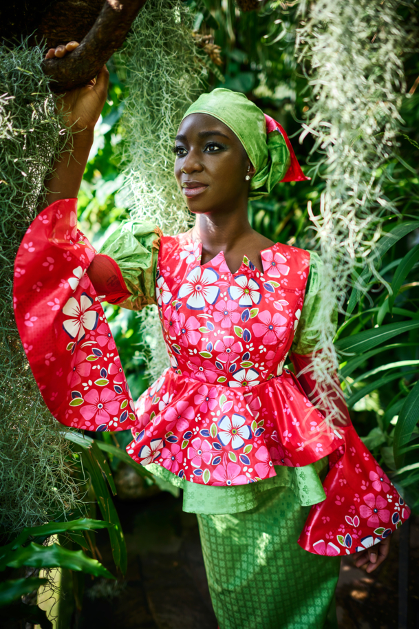 Frau in Kleid mit Blumendruck unter Palmen
