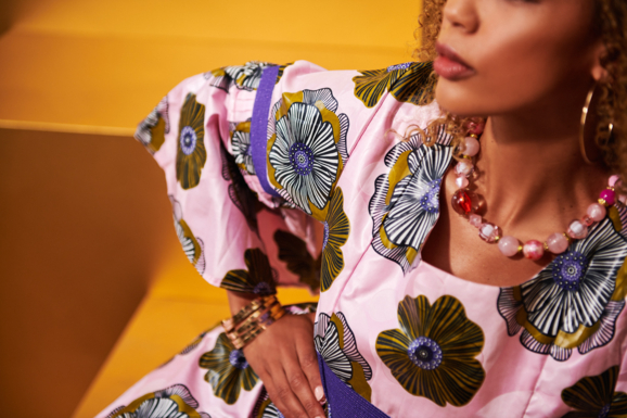 Sitting woman in pink dress with floral pattern