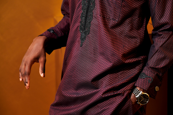 Detailansicht eines eleganten Herrenoutfits, bestehend aus einem Damastgewand mit charakteristischen Mustern und Stickereien von Getzner Textil, das die feine Qualität der African Fashion widerspiegelt.