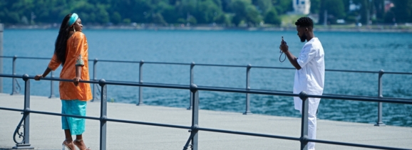 Mann fotografiert Frau am Ufer eines Sees