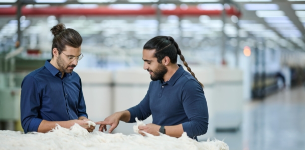 2 hommes discutent de coton écru dans une filature